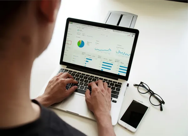 Norsk bedriftseier vurderer finansielle alternativer på laptop ved skrivebord