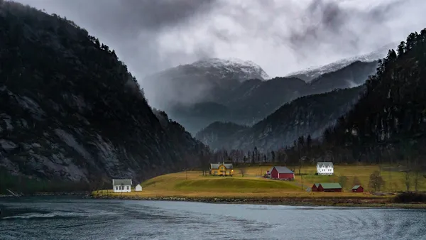 Norsk familiegård med våningshus og driftsbygning ved generasjonsskifte mellom foreldre og barn