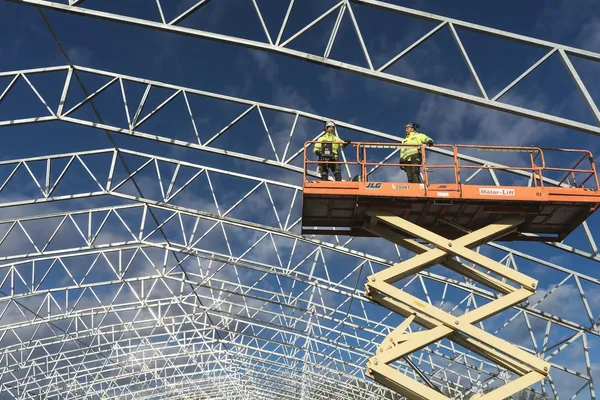 Stor teleskoplift JLG i drift på norsk byggeplass med arbeidstaker i kurven