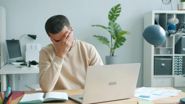 Bedriftseier vurderer en uventet restskatt-regning ved laptopen